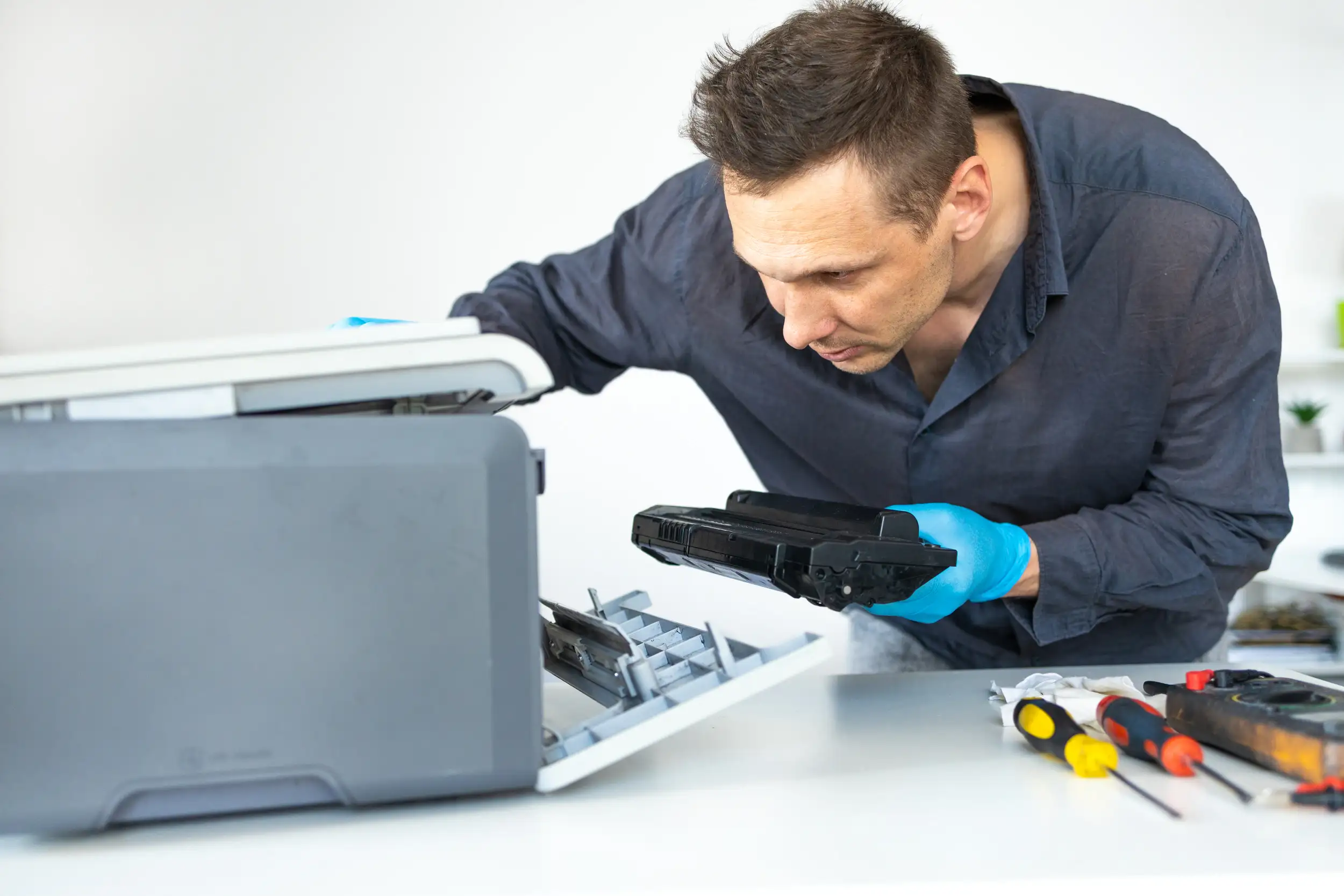 Technician checking and adjusting something inside the digital printer.
